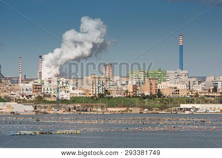 White Smoke Going Up From The Chimney Of Steel Plant Of  Taranto, Puglia. Italy