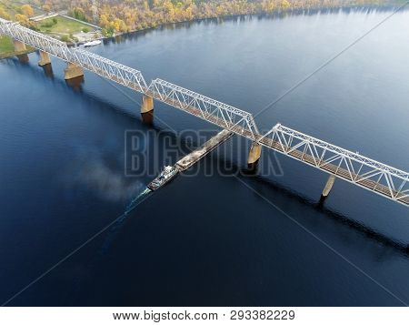 Scenic Aerial Cityscape Of Kiev And River Dnipro At Sunset. Tugboat Supporting Barge With Sand Bulk 