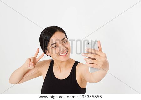 Sexy, Pretty Asian,korean Woman Taking A Selfie And Show Sight Of Peace Or Viktory Isolated On White