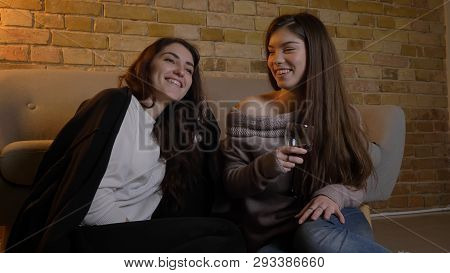 Closeup Portrait Of Two Young Pretty Women Watching A Movie Tv Chilling With Wine Laughing Happily S