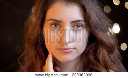 Closeup Shoot Of Young Pretty Caucasian Female With Brunette Curly Hair Looking Straight At Camera W