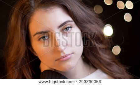 Closeup Shoot Of Young Pretty Caucasian Female With Brunette Curly Hair Being Thoughtful And Looking