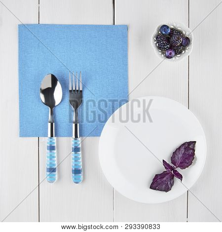 Still Life With Cutlery And Blackberries On A Light Background