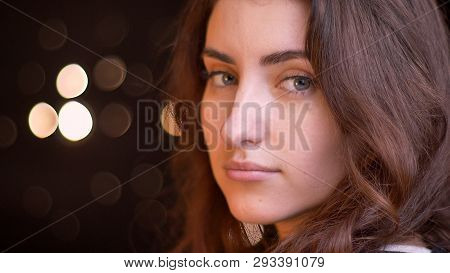 Closeup Side View Shoot Of Young Attractive Caucasian Female Face Turning And Looking At Camera With