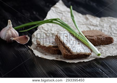 Close-up Of Black Bread With Lard, Green Onions And Garlic