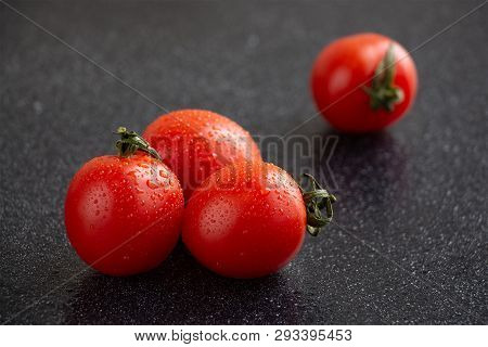 Close-up Of Cherry Tomatoes With Water Drops With Black Background