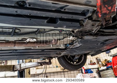 The Exhaust System In The Car Seen From Below, The Car Is On The Lift In The Car Workshop.