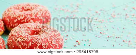 Donuts Decorated With Icing On Blue Background.