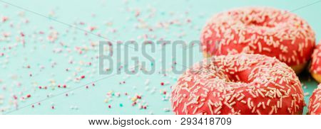 Donuts Decorated With Icing On Blue Background.