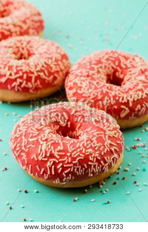 Donuts Decorated With Icing On Blue Background.