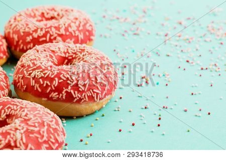 Donuts Decorated With Icing On Blue Background.