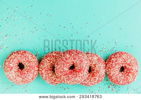 Donuts Decorated With Icing On Blue Background.