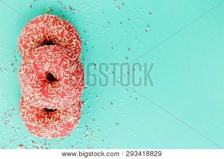 Donuts Decorated With Icing On Blue Background.