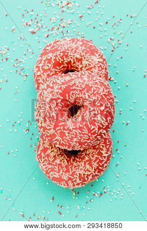 Donuts Decorated With Icing On Blue Background.