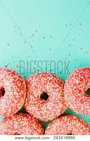 Donuts Decorated With Icing On Blue Background.