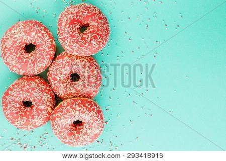 Donuts Decorated With Icing On Blue Background.