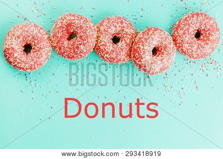 Donuts Decorated With Icing On Blue Background.