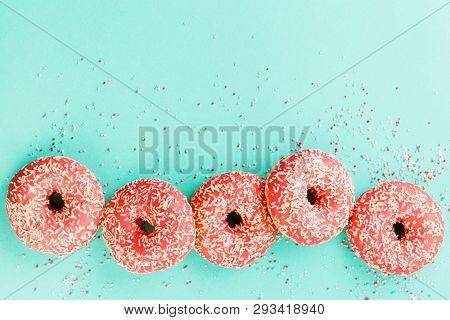 Donuts Decorated With Icing On Blue Background.