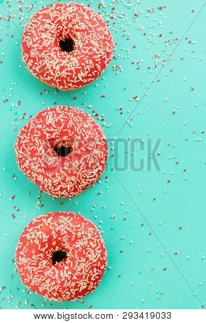 Donuts Decorated With Icing On Blue Background.