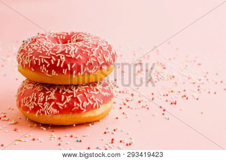 Two Coral Donuts Standing In A Line. Donuts Decorated With Icing