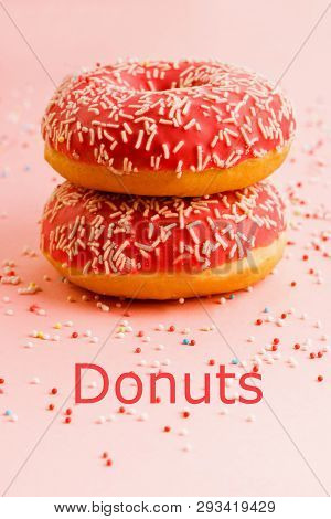 Two Coral Donuts Standing In A Line. Donuts Decorated With Icing