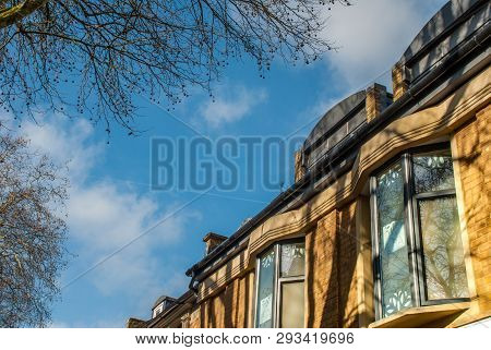 The Afternoon Sun Shines Through The Beautiful Orange Brick House.