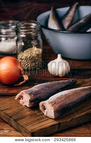 Hake Carcasses On Cutting Board With Pepercorn, Garlic And Salt