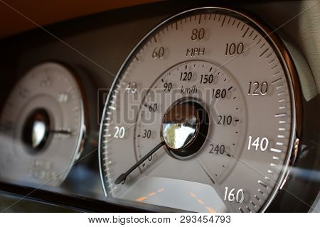 Luxury car bespoke interior dash containing speedometer and gauge cluster instrument panel.