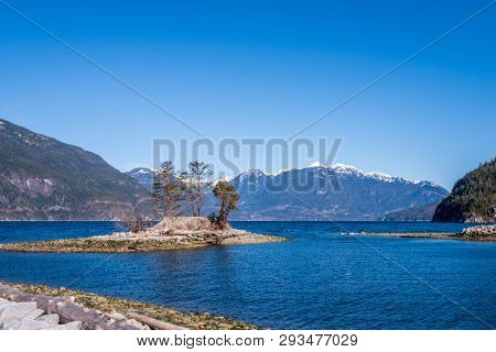 Fantastic view over ocean, snow mountain and rocks at Sechelt inlet in Vancouver, Canada.