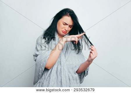 Upset Young Beautiful Girl In A Gray Robe, Folding Her Fingers In The Form Of Scissors Cuts Off A St