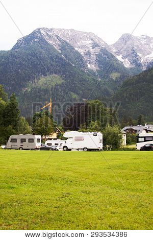 Autocampers Are On Campground Parking In The Alpine Mountains
