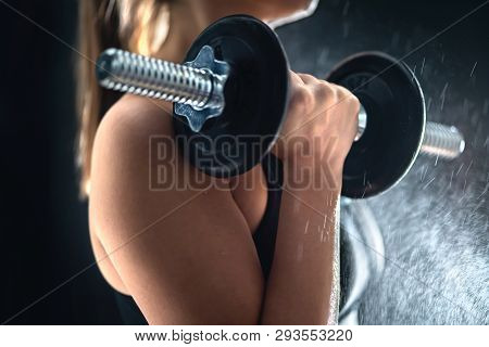 Fitness Athlete Doing Bicep Curls With Dumbbell. Fit Woman Working Out In Gym. Sweat Or Water Splash