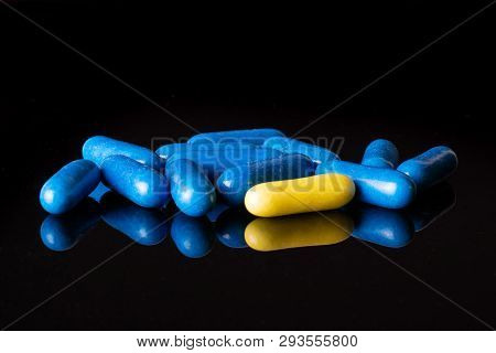 Lot Of Whole Blue And One Yellow Sweet Licorice Comfit Isolated On Black Glass