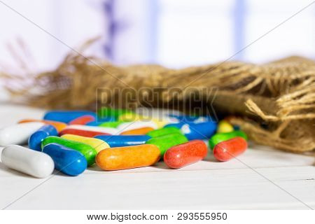 Lot Of Whole Sweet Licorice Comfit On Jute Cloth With Blue Window In Background