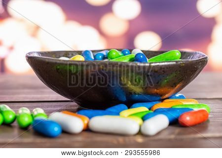 Lot Of Whole Sweet Licorice Comfit On Grey Ceramic Plate With Lights In Dark Background