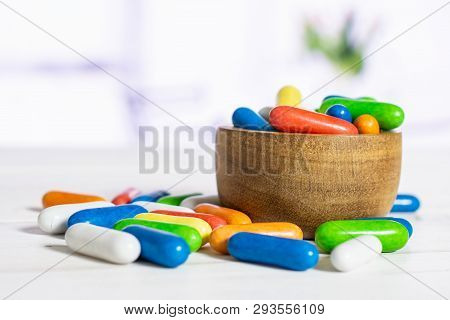 Lot Of Whole Sweet Licorice Comfit In A Wooden Bowl With Flowers In A White Kitchen