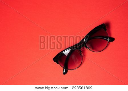 Sunglasses Lie On A Red Background, Close-up.