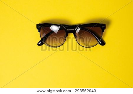 Sunglasses Lie On A Yellow Background, Close-up