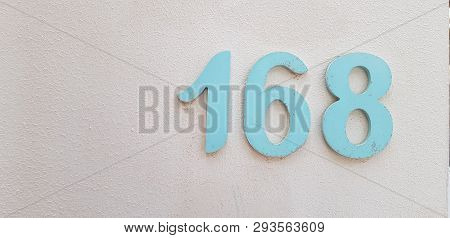 Number 168 Big Blue Digits On White Painted Wall