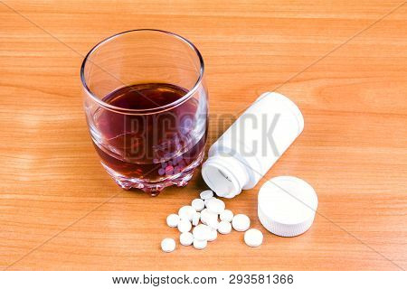 Glass Of The Whiskey With A Pills On The Table Closeup
