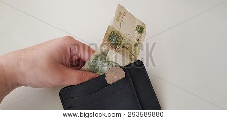 Black Wallet With Two Hong Kong Dollars Coin While A Hand Takes Out One Yuan Banknote