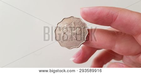 Hong Kong Dollar Coin On Female Finger On White Background