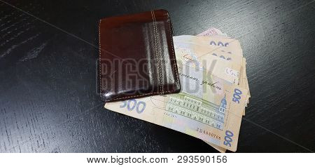 Brown Leather Wallet Full With Five Hundred Hryvnia Banknotes Lay On Black Table