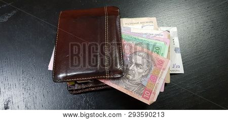 Brown Leather Wallet Full With Hryvnia Banknotes Lay On Black Table