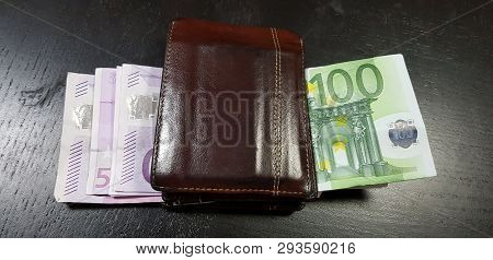 Brown Leather Wallet Full With Euro Banknotes Lay On Black Table