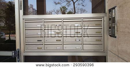 Metal Individual Mail Boxes With Apartment Numbers At The Entrance To Shared Building