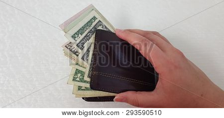 Female Hand Isolated On White Background Opens Brown Leather Wallet Full Of Various American Dollar 