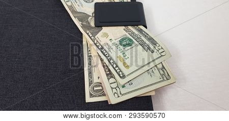 American Dollar Bills Catched In A Magnet Pocket Of Black Leather Folder