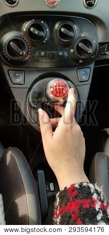 Woman In Fashion Coat Holding Right Hand On Manual Transmission Stick Six Speeds