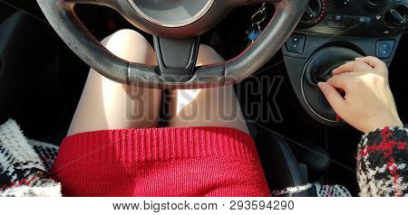 Woman In Red Mini Dress Sitting On Drivers Seat Of Mini Sport Car Holding Right Hand On Transmission
